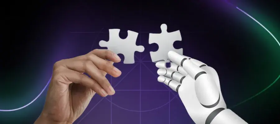 human hand and a robotic hand each holding a jigsaw peice that will fit together